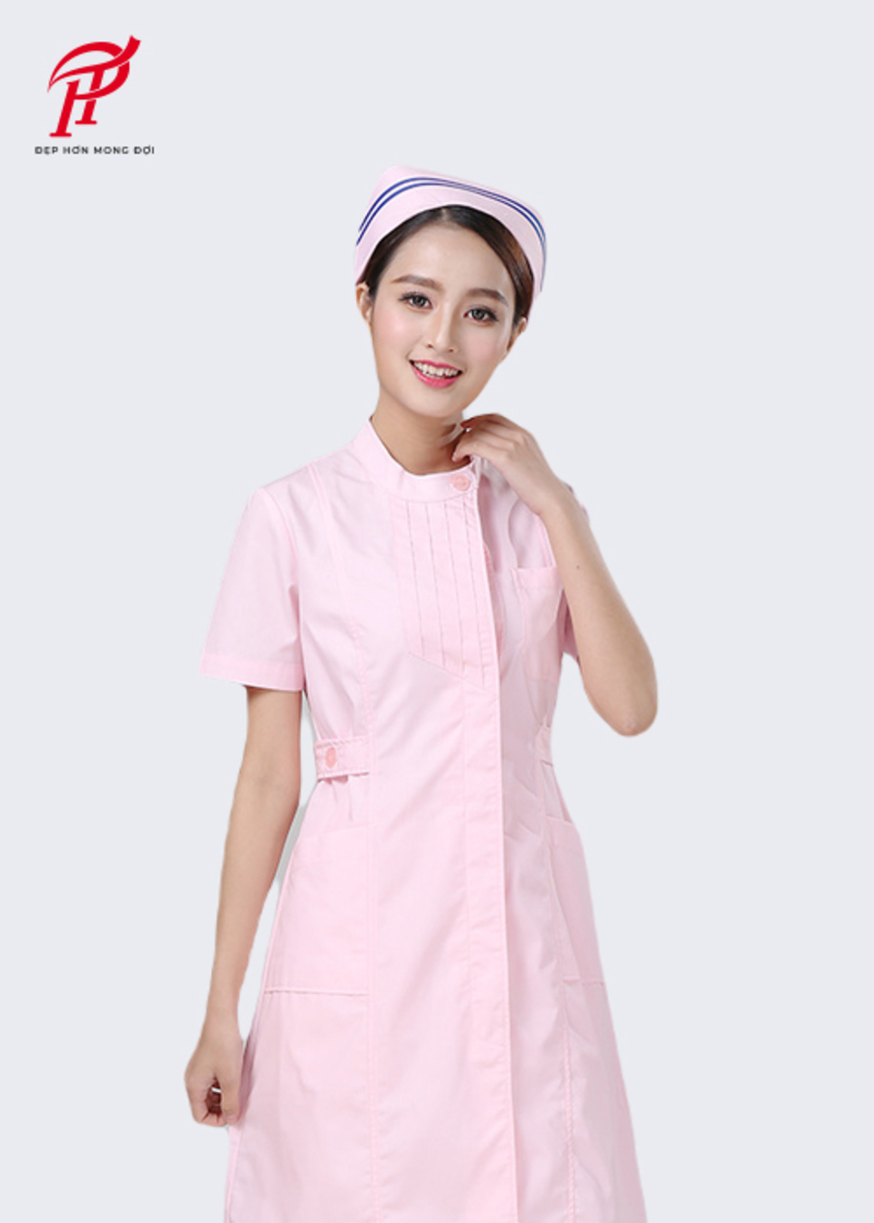 Mẫu đồng phục dành cho y tá với váy dài ngang gối, túi ốp cỡ lớn để đựng dụng cụ y tế tiện lợi. Đây là mẫu thiết kế dành cho y tá tại các bệnh viện tư với màu hồng nhẹ nhàng kết hợp với mũ đội đầu cùng màu thanh lịch.