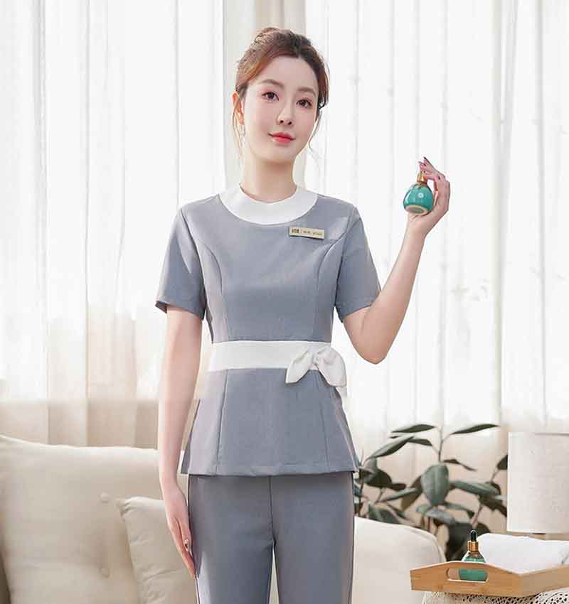 Mẫu đồng phục spa gam màu xám phối cổ viền trắng và thắt nơ ở eo tạo điểm nhấn